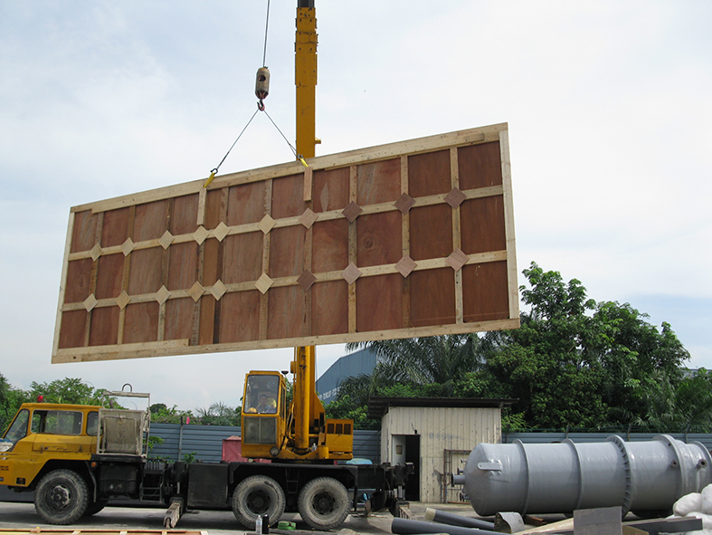 Large wooden crate being loaded using mobile crane.